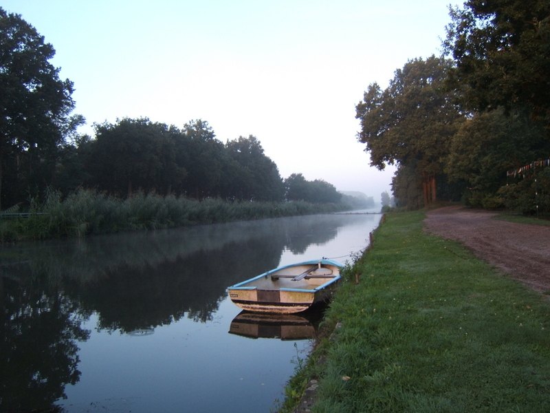 Roeiboot aan de oever van het kanaal langs Camping Frerichsoord in de ochtendmist